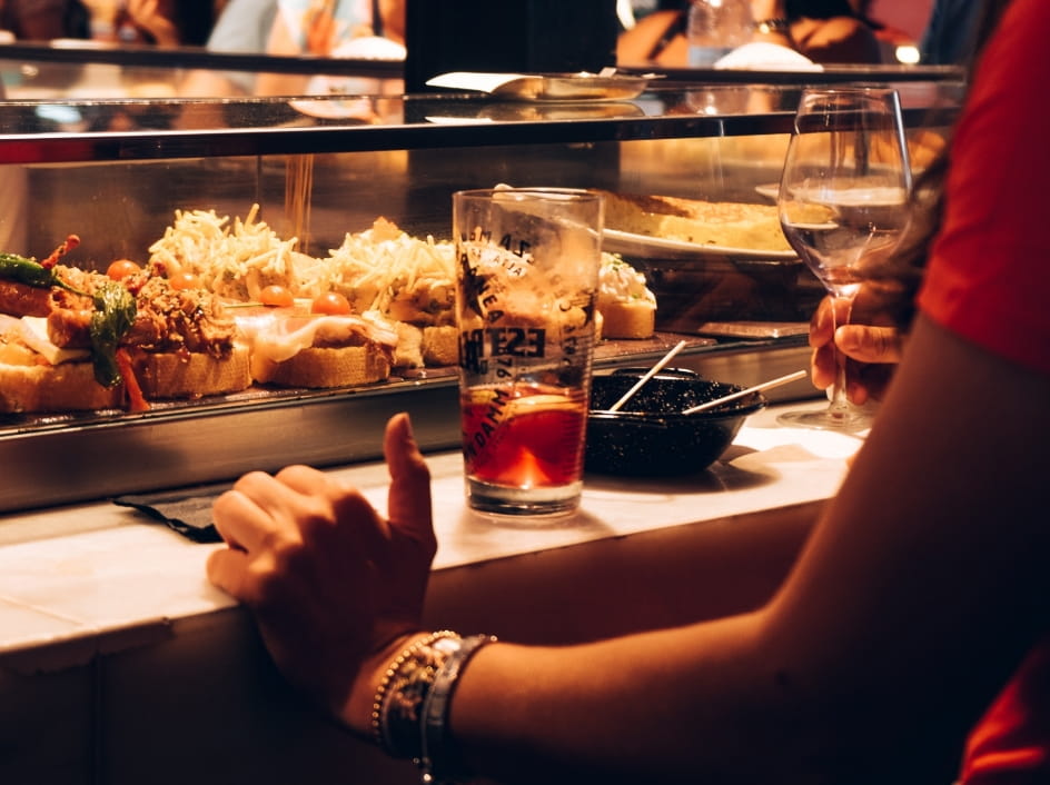 バーカウンターに並ぶピンチョス風の料理とドリンク類