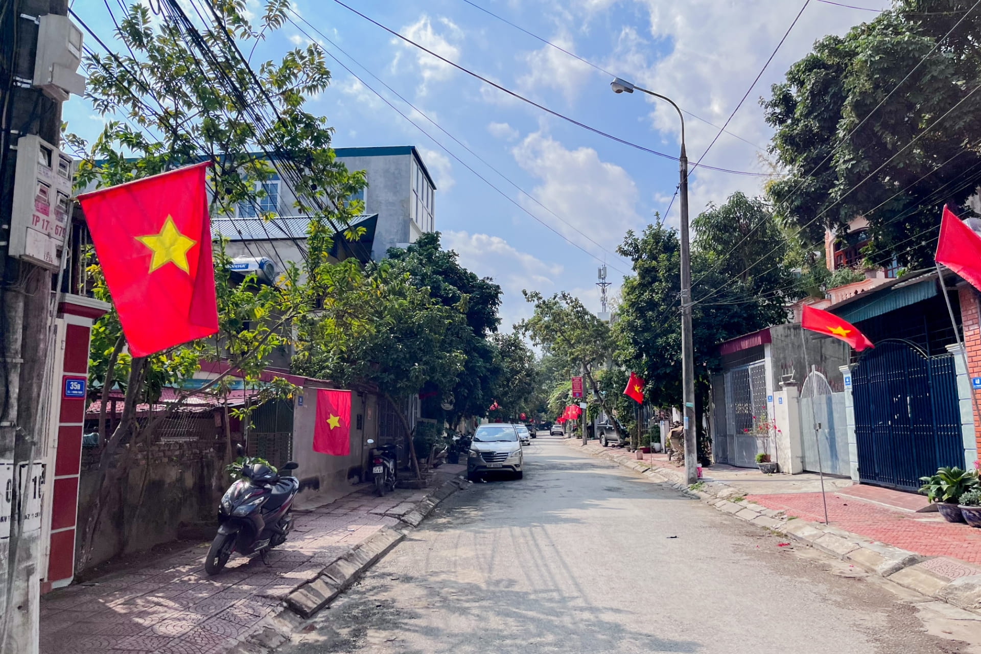 静かな住宅街の道沿いにベトナム国旗が多数掲げられている